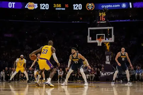 LeBron James z Lakersów z piłką, w tle wynik 120-120 w dogrywce. W koszykówce są cztery kwarty.