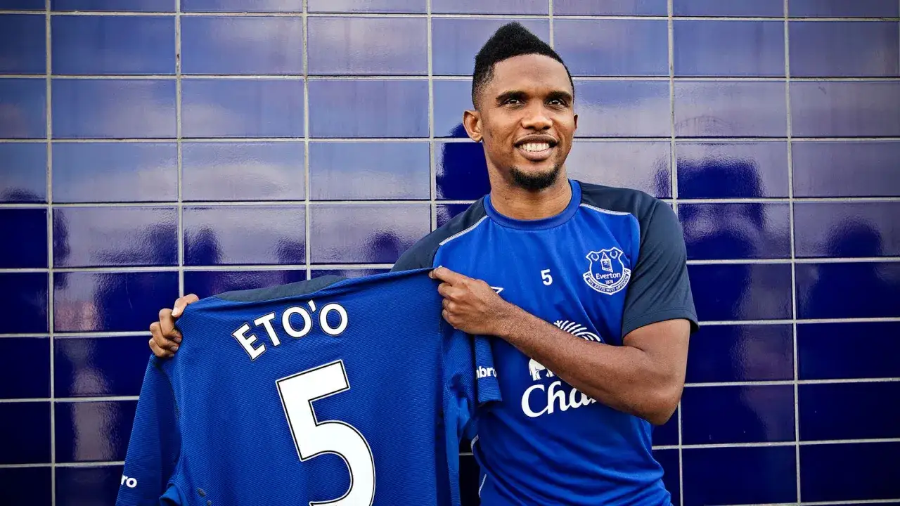 Piłkarz Evertonu, Samuel Eto'o, prezentuje koszulkę z numerem 5. Widoczne są numery na koszulkach piłkarzy.